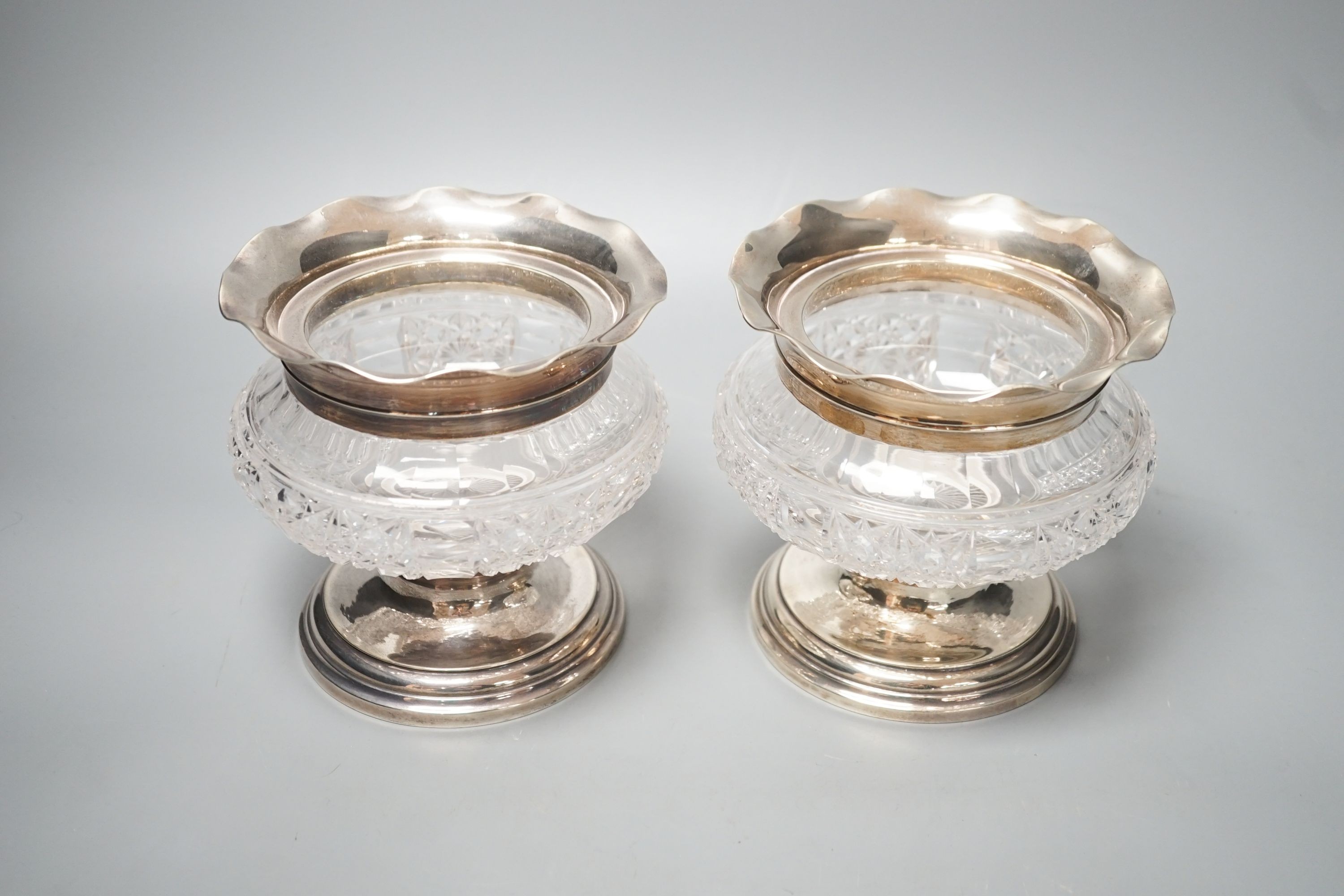 A pair of Edwardian silver mounted glass bowls, (lacking covers), Birmingham, 1904, height 13.4cm.
